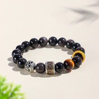 Bracelet de protection Om Mani Padme Hum en obsidienne œil de tigre et reflets argentés de KarmaRipple