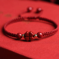 Bracelet en fil rouge avec trèfle à quatre feuilles et fleur de cinabre à cinq pétales de KarmaRipple