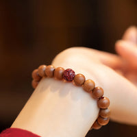 Bracelet de richesse en bois de pêcher, lotus et cinabre de KarmaRipple