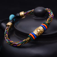 Bracelet tibétain fait main en bronze avec huit fils tissés et une pièce de monnaie porte-bonheur de KarmaRipple