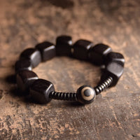 Bracelet de force en perles dzi en bois d'ébène tibétain de KarmaRipple